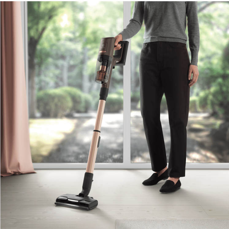 Osoba držící vysavač